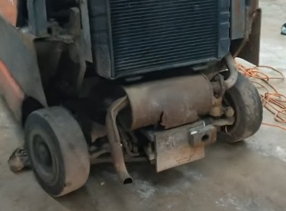 A Toyota forklift muffler exposed for maintenance services.